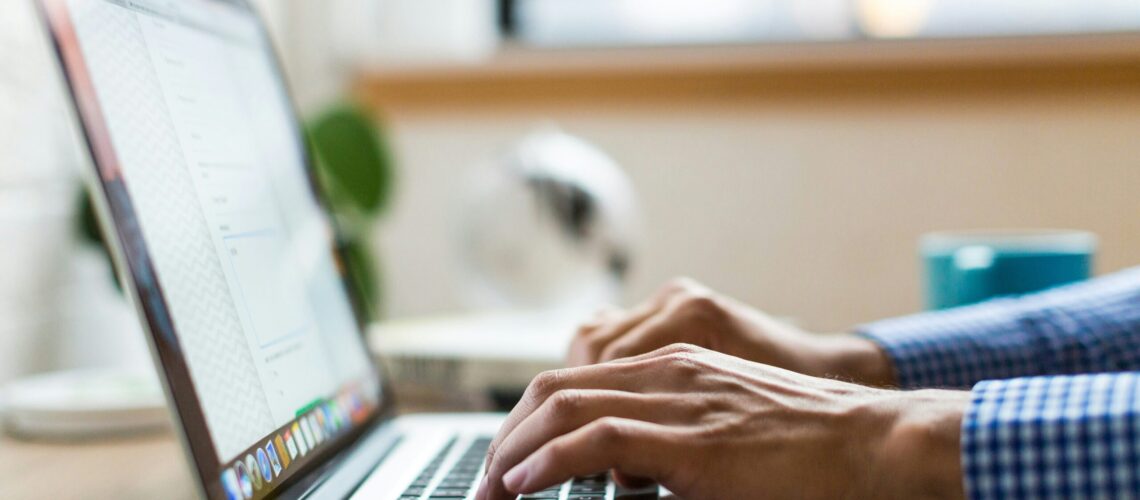 person typing on silver Macbook