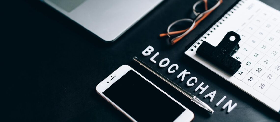 Free Flat lay of a modern digital workspace with blockchain theme, featuring a smartphone and calendar. Stock Photo