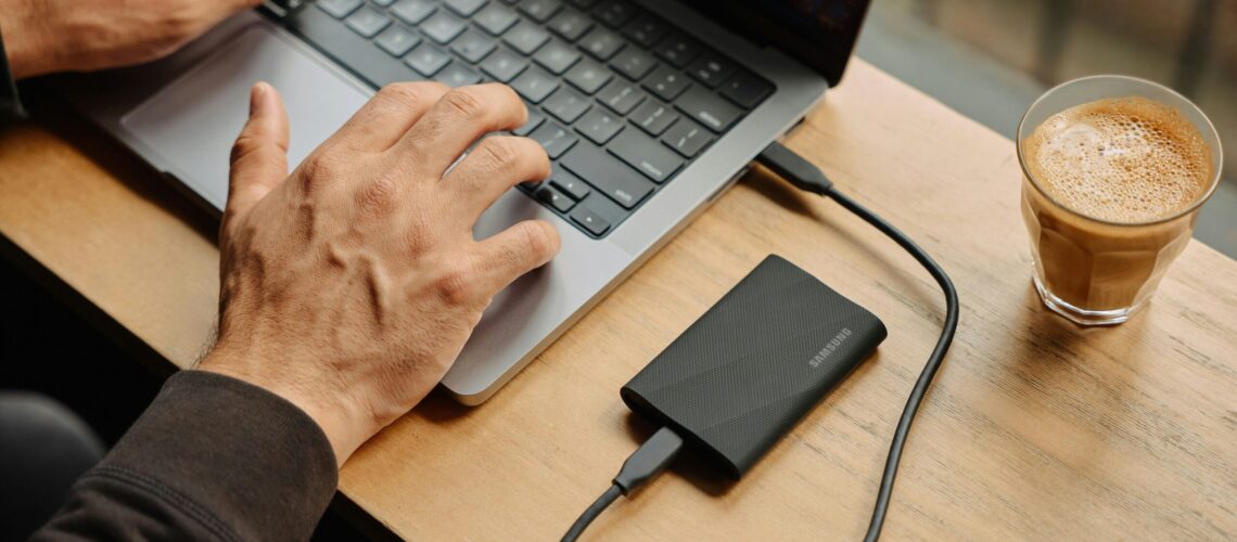 A man sitting at a table using a laptop computer