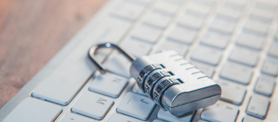 A combination lock rests on a computer keyboard.